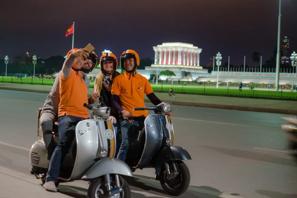 Travellers and local guides exploring Hanoi on a Vespa tour